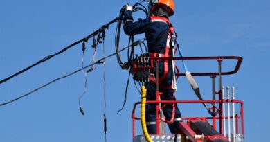 Local Electrician working on a post